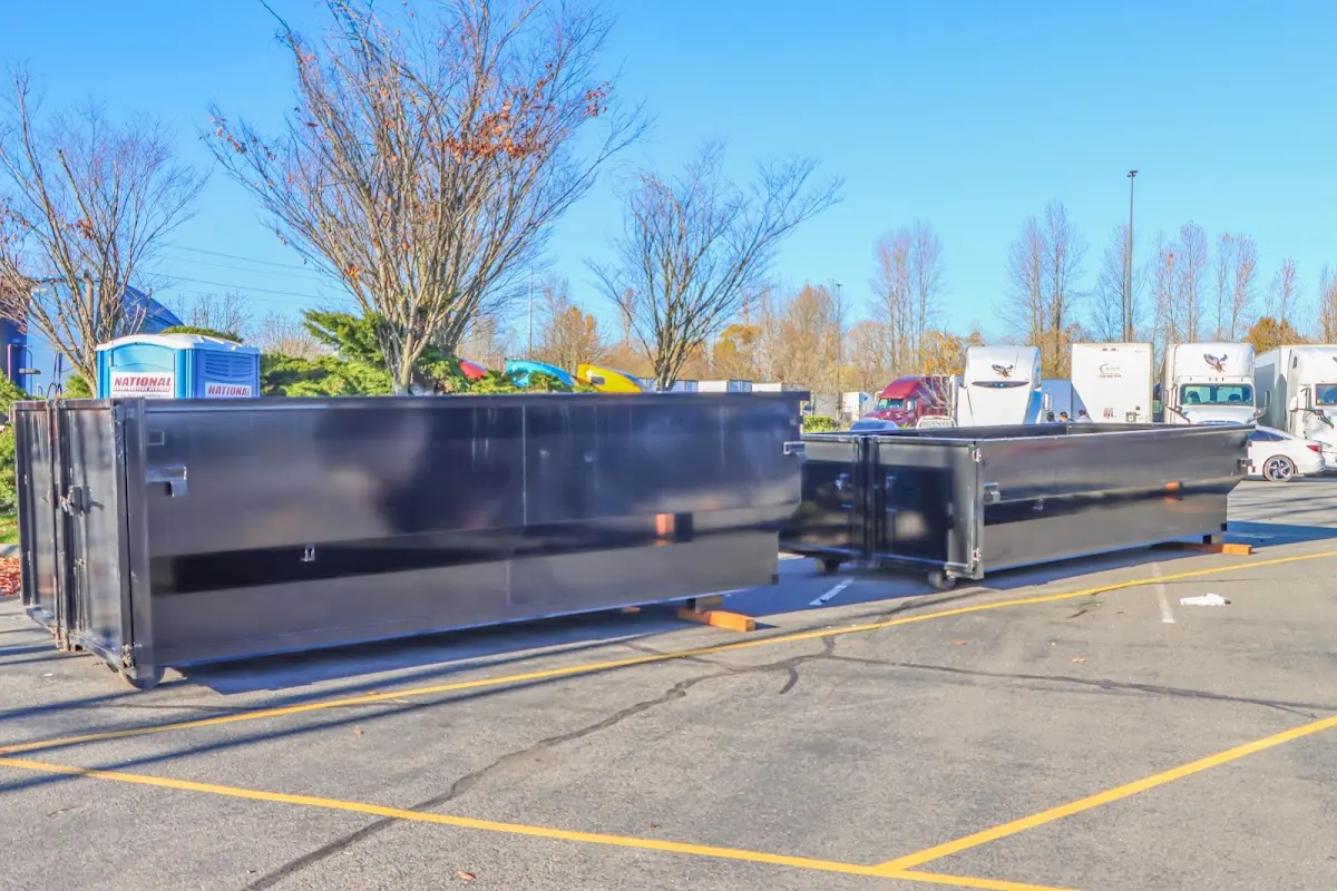 Professional dumpster rental service with roll-off container on residential driveway in Russellville